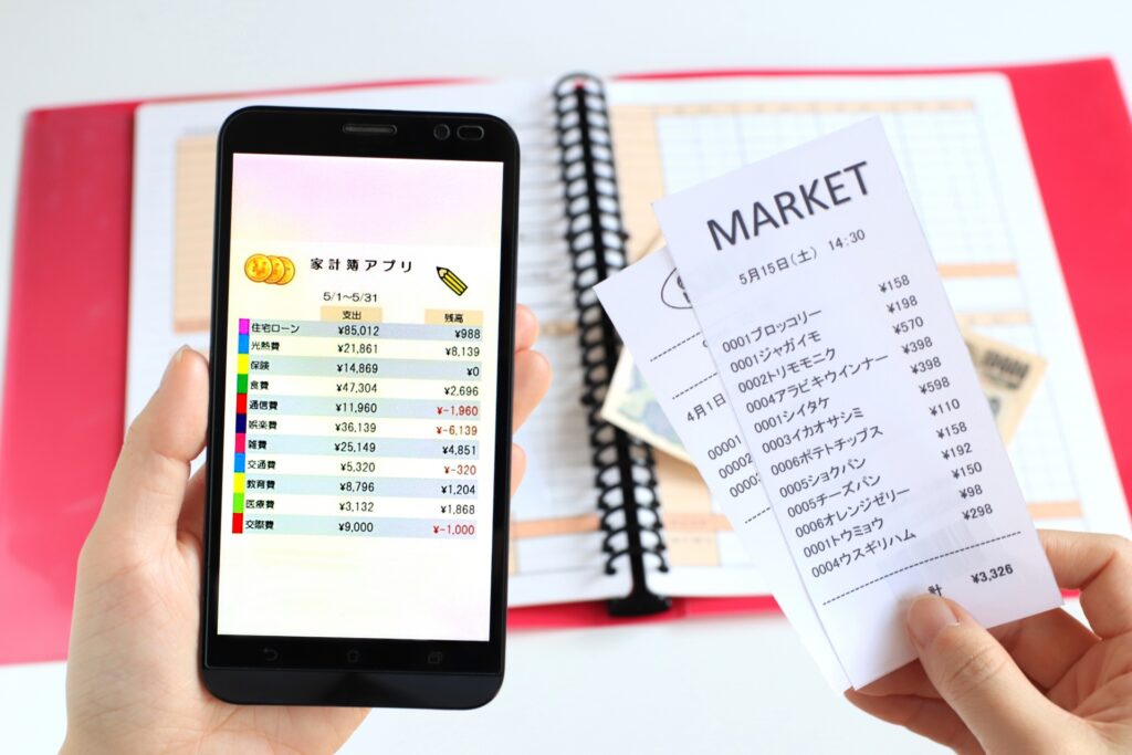 レシートと財布、スマートフォン。不審な出費とデジタル証拠を象徴する画像。