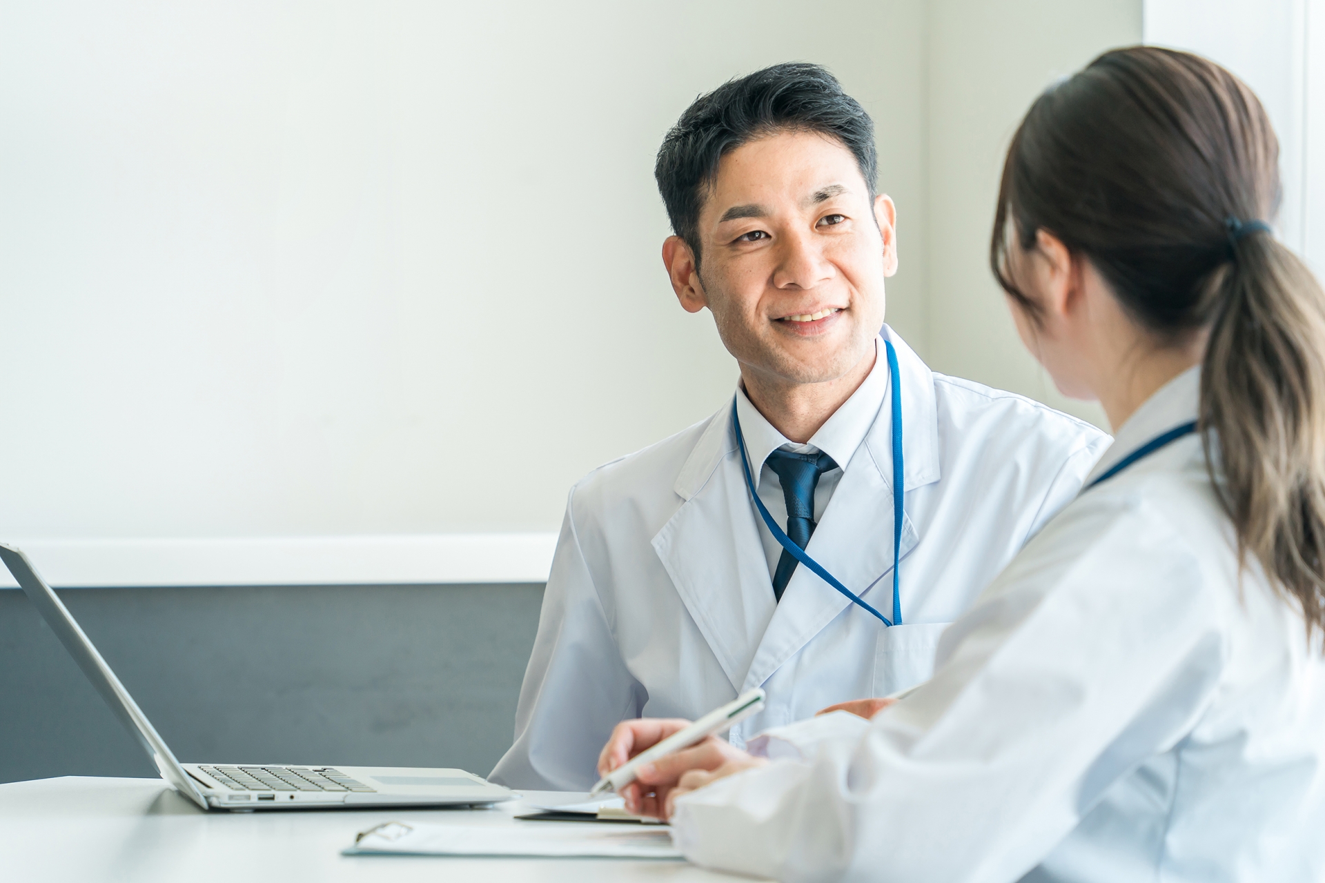 病院の廊下でこっそりアイコンタクトを取る医師と看護師のイラスト